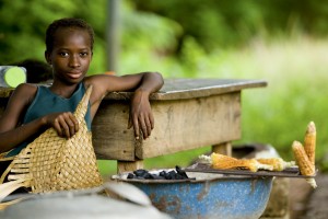 A teenager grills corn, Cote d?Ivoire.