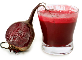 A glass of fresh beet vegetable juice isolated on white background.
