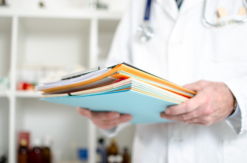 Doctor holding files in his office